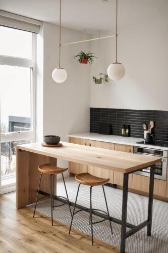 a kitchen with a wooden table and two stools at Lokal Hotel Fishtown in Philadelphia