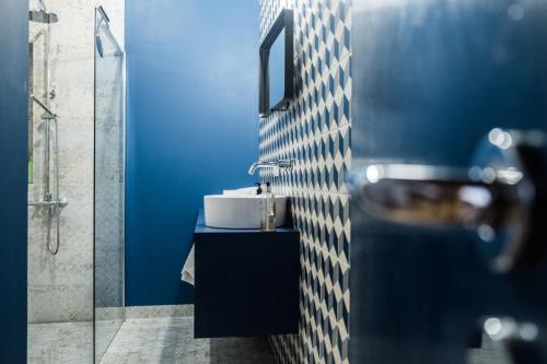 a bathroom with a sink and a blue wall at Apartament GALERIA in Zielona Góra