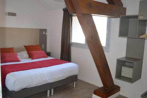 a bedroom with a bed with a red blanket at Logis Hotel du Parc-Restaurant - Le Rouget de Lisle in Lons-le-Saunier
