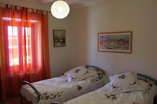 1 Schlafzimmer mit 2 Betten neben einem Fenster in der Unterkunft Casa Rosmarino in Gordola