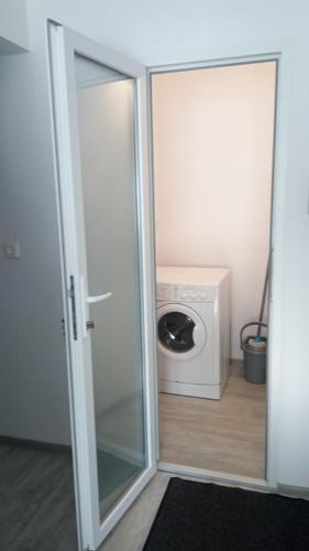 a sliding glass door leading to a washing machine at Apartament Elena in Târgu-Mureş