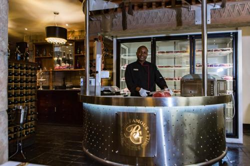 a man standing behind a counter in a kitchen at Cape Town Lodge Hotel in Cape Town
