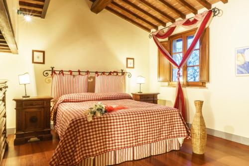 a bedroom with a bed with a red and white blanket at Tenuta Sant'Ilario in Gambassi Terme