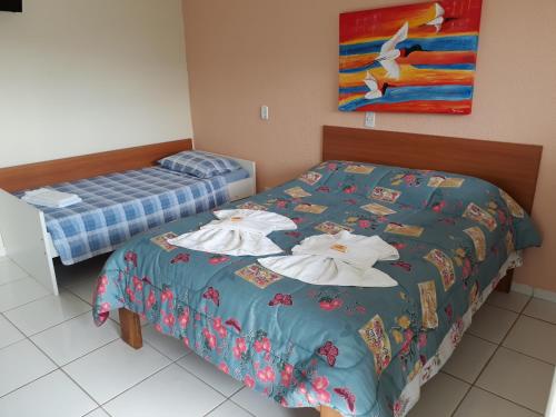 a bedroom with two beds with towels on them at Pousada Canto da Ilha in Ilha Comprida