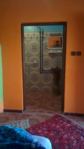 a room with a bathroom with a mirror and a door at Auberge Camping BOUGAFER Tamtetoucht in Tamtetoucht