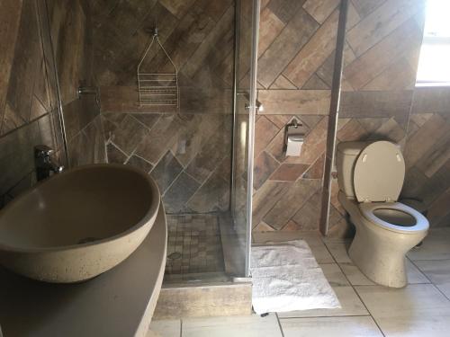 łazienka z wanną, toaletą i prysznicem w obiekcie Aquila Guest House w mieście Pretoria