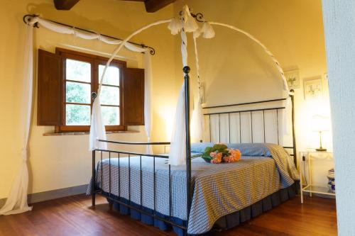 a bedroom with a canopy bed with flowers on it at Tenuta Sant'Ilario in Gambassi Terme