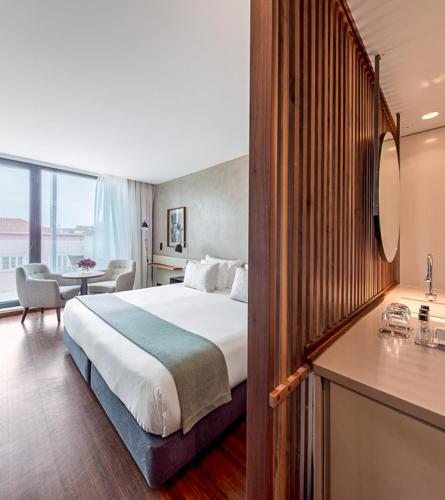 a hotel room with a large bed and a desk at Lux Lisboa Park in Lisbon