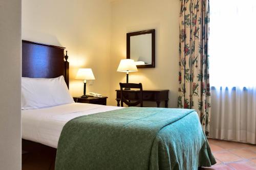 Un pat sau paturi într-o cameră la Villa Termal Monchique - Hotel Termal
