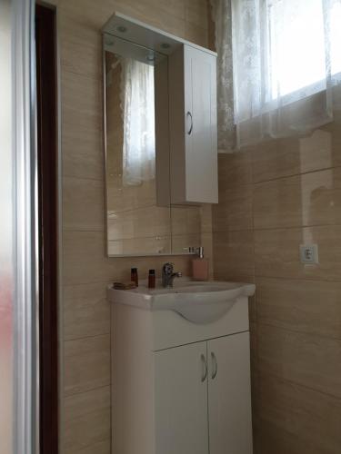 a bathroom with a white sink and a mirror at Apartmani Hršak in Krapina