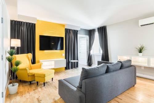 a living room with a couch and a yellow chair at Capitol Robinson by Bower Boutique Hotels in Moncton