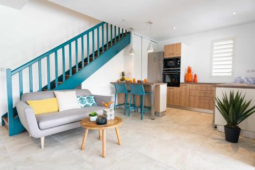 a living room with a couch and a kitchen at Villas Rock & Beach in Le Diamant
