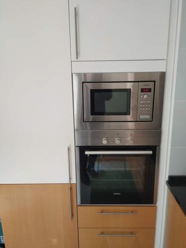 a microwave oven sitting inside of a kitchen at Apartamento Marina Olhão in Olhão