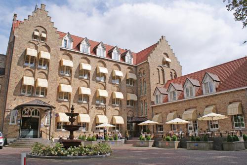 a large brick building with a fountain in front of it at Fletcher Hotel-Restaurant de Dikke van Dale in Sluis