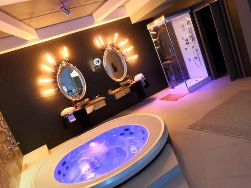 a bathroom with two mirrors and a sink at Hotel Ramka & Restaurant & Wine Bar in Poznań