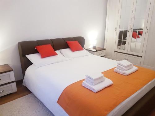 a bedroom with a large white bed with red pillows at Dream Apartment Brasov - West in Braşov