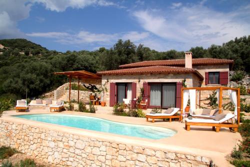 a villa with a swimming pool in front of a house at Amapola Boutique Villas with Sea Access - Phos in Sivota