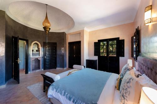 um quarto com uma cama grande e um cobertor azul em Residence Dar Lamia Marrakech em Dar Caïd Layadi