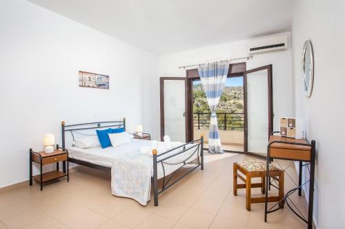 een slaapkamer met een bed en een groot raam bij Blue Horizon Apartment in Kalathos