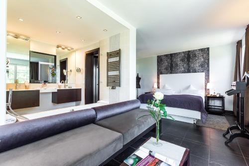 - un salon avec un canapé et une chambre dans l'établissement Hotel Seezeichen Ahrenshoop, à Ahrenshoop