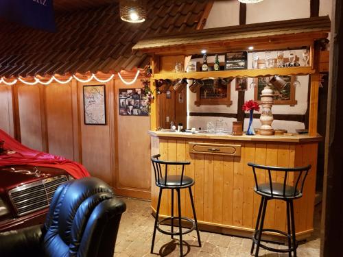 a bar in a room with two stools at Home&Classic Erlebnisscheune in Effelder