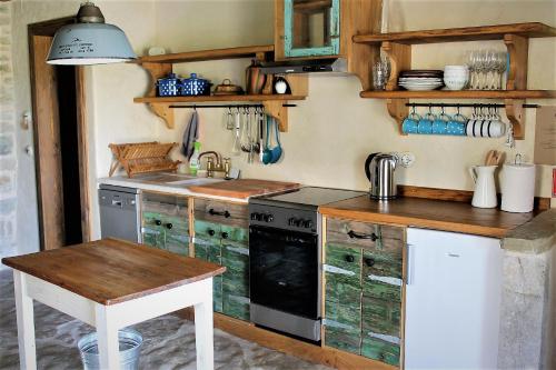 a kitchen with a stove and a sink and a table at Bolara 60: the Cottage in Grožnjan