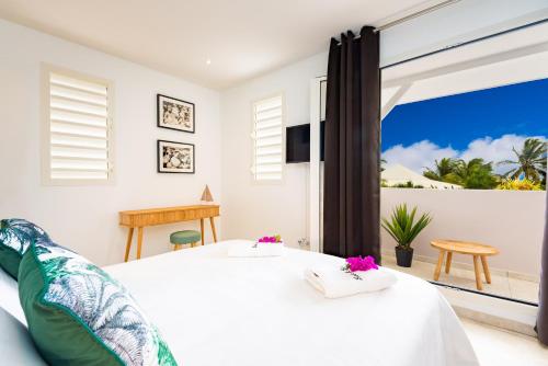 a bedroom with a bed with a view of the ocean at Villas Rock & Beach in Le Diamant