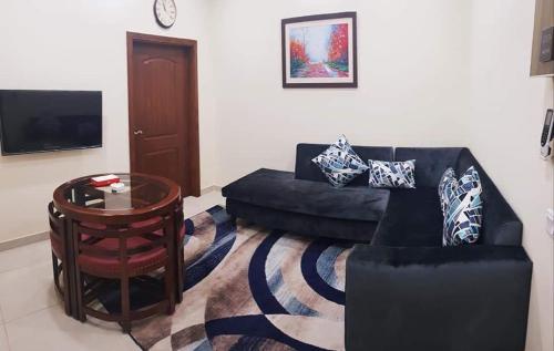 a living room with a couch and a table at Hayyat Luxury Hotel Apartments in Lahore
