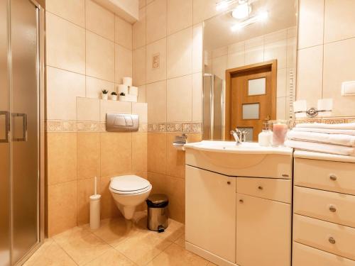 La salle de bains est pourvue de toilettes, d'un lavabo et d'une douche. dans l'établissement VacationClub – Olymp Apartament 211, à Kołobrzeg