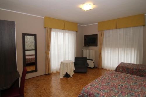 桑特伊阿的住宿－hotel ristorante vittoria，一间卧室配有两张床、一张桌子和一台电视。