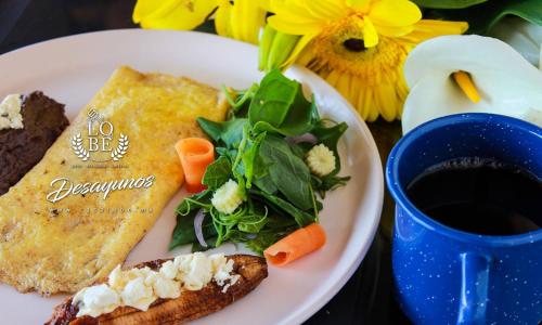a plate with food and a cup of coffee and flowers at Casa LOBE in Ocosingo