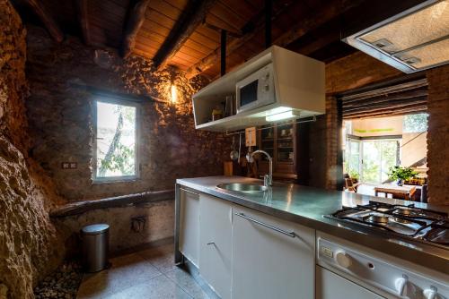 eine Küche mit Spüle und Herd oberen Backofen in der Unterkunft El Risco del Lomero, chimenea 4 Huesp max in Valdelarco
