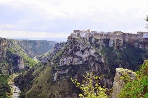 een kasteel op de top van een berg met een rivier bij Il Pendio in Castellaneta