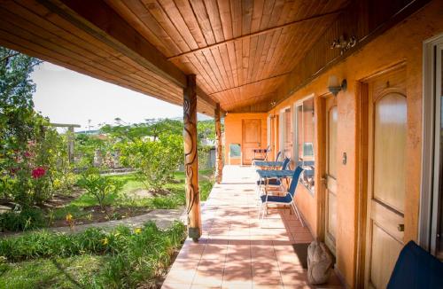 a porch of a house with a wooden roof at Hotel Taura'a in Hanga Roa
