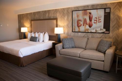 a hotel room with a bed and a couch at Canalta Airdrie in Airdrie