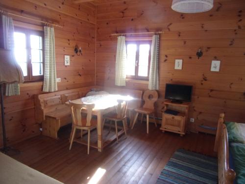 ein Zimmer mit einem Tisch und Stühlen in einem Blockhaus in der Unterkunft Biohof/Gästezimmer Adam in Großklein