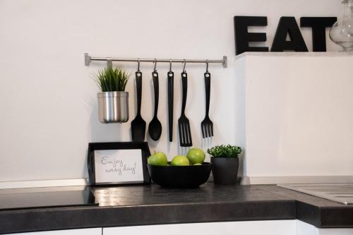 a kitchen counter with a bowl of apples and utensils at Alloggio Turistico al Civico n 32 in Foligno