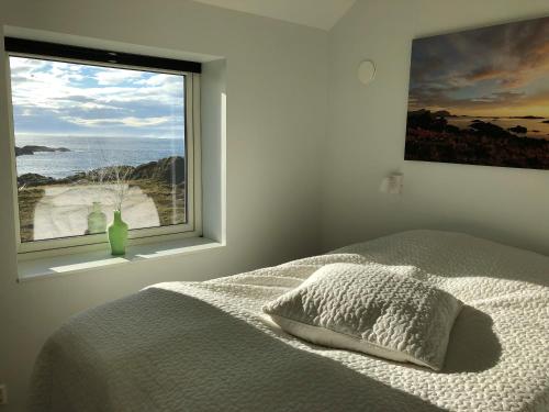 a bedroom with a bed and a large window at Nyksund, Huset på Skåltofta in Nyksund