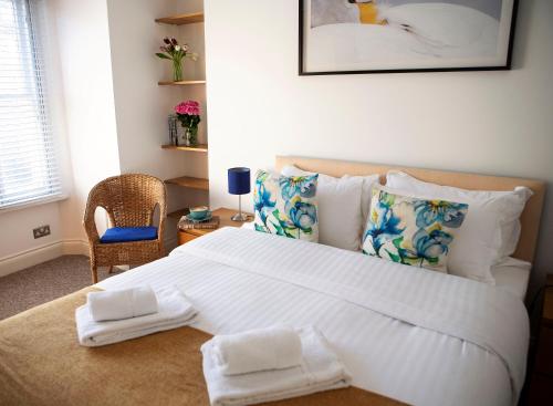 een slaapkamer met een groot wit bed met kussens bij Apt 1, Opera House 2nd Floor by Indigo Flats in Londen