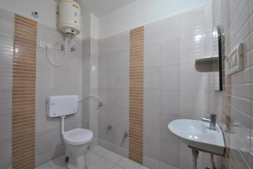 a bathroom with a toilet and a sink at Satkar Hotel in Jaipur