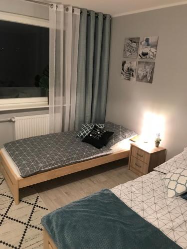 a bedroom with two twin beds and a window at BlaBlaFlat Świnoujście Grunwaldzka in Świnoujście