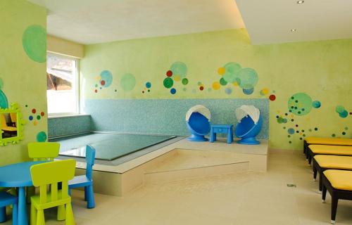 a childrens play room with a pool and tables and chairs at Sporthotel Neustift in Neustift im Stubaital