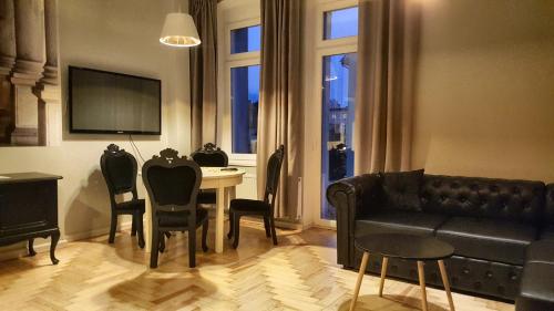 a living room with a couch and a table with chairs at Classic Apartments - Top Location, bezpłatny parking in Ełk