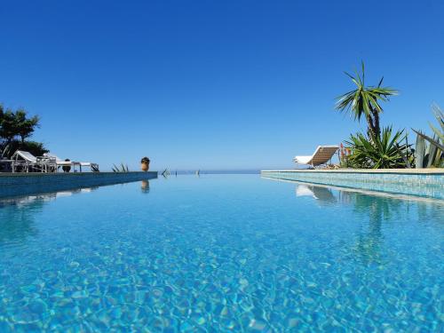 a large pool of blue water next to a beach at Kasbah Tabelkoukt in Mirleft