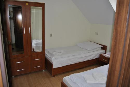een kleine slaapkamer met 2 bedden en een spiegel bij Zajazd Dworek in Mircze