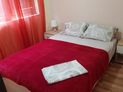 um quarto com uma cama com lençóis vermelhos e brancos em TravelStop #GoldenSea em Varna City