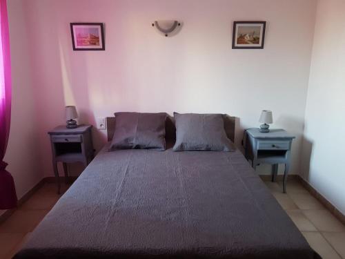 um quarto com uma cama grande e duas mesas em Appartement de l'olivier em Saintes-Maries-de-la-Mer