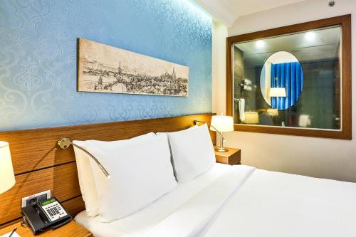 a hotel room with a bed and a telephone at Radisson Blu Hotel, Kyiv Podil City Centre in Kyiv