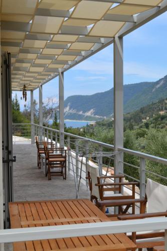 a porch with chairs and a view of the water at Av Apartment in Agios Nikitas