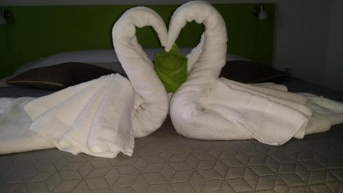 a bed with two towels shaped like swans at Vila William’s in Braşov